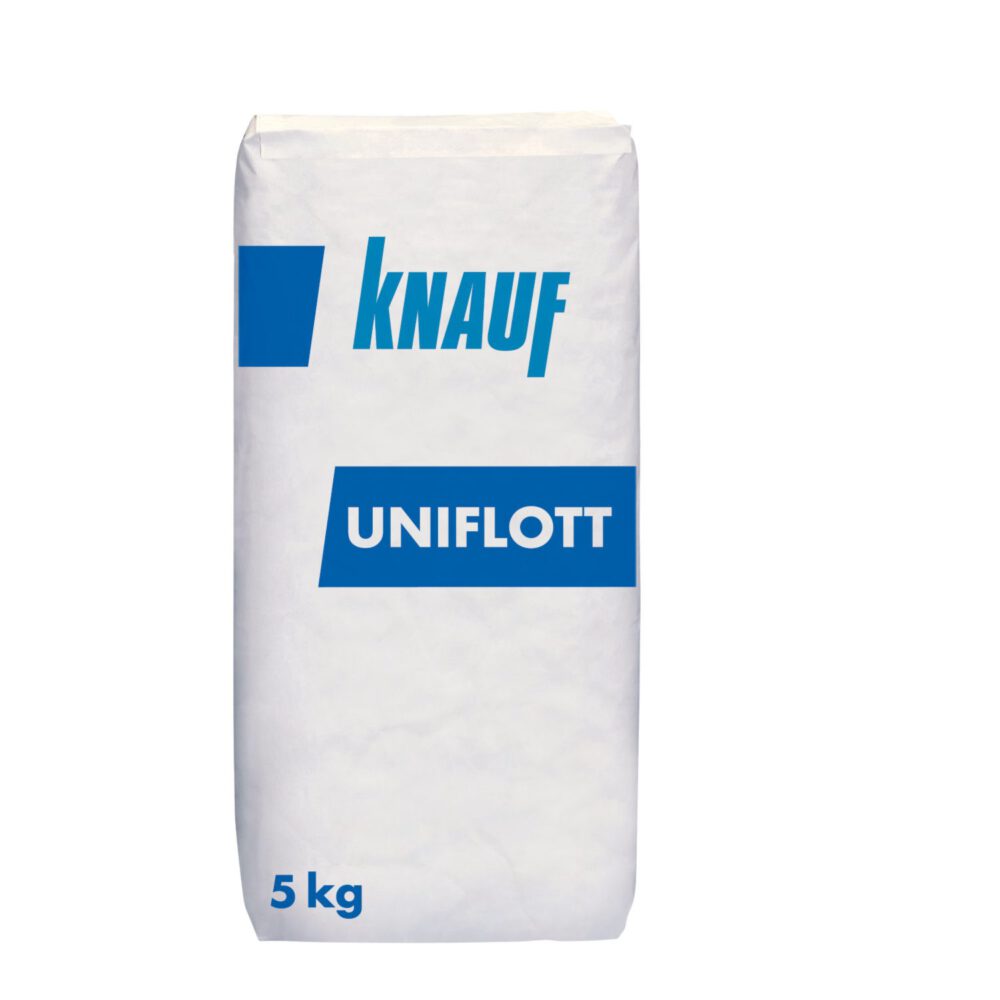 Eine Hand in einem blauen Knauf Ärmel verteilt mit einer Kelle den beigen Knauf Uniflott Spachtelmasse 5kg auf einer Wand.